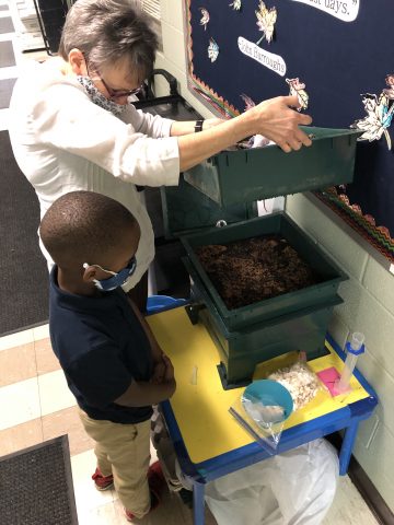 Joshua and Mrs. Kaiser inspect our worm farm.