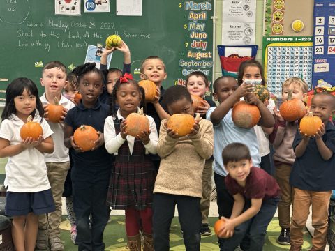 Students show off their treasures from the pumpkin patch.